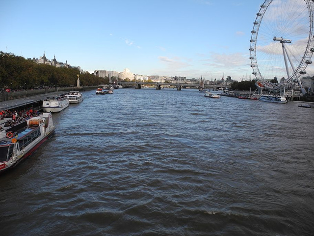 游船在泰晤士河上航行,看到河南畔的伦敦眼～一座圆形的观光缆车,感觉