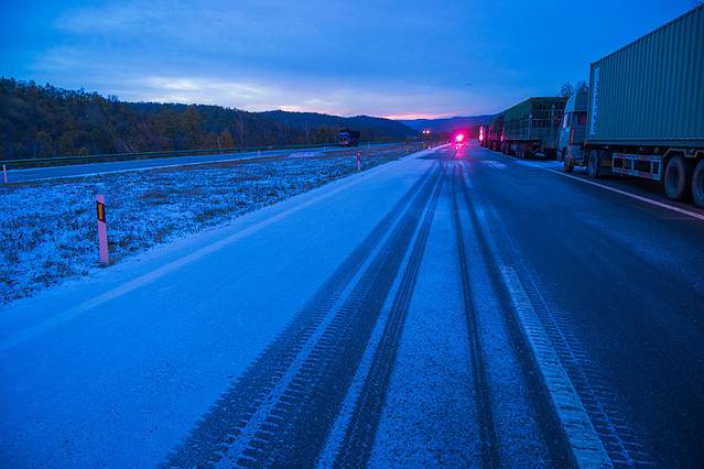 凌晨时分的绥满高速大兴安岭路段,冰雪覆盖着路面,排队等待中.