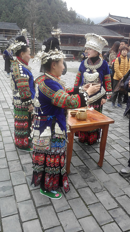 我们正好赶上苗民们为游客举行的欢迎仪式,苗族的年轻姑娘们向游客进