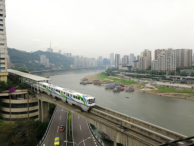 重庆的轻轨真的是上天入地,或在楼房之间穿梭,或沿江而行,一路风景