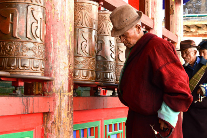 寺内的走廊上,有很多信众在磕长头,许多人坚信要这样磕满10万个才能