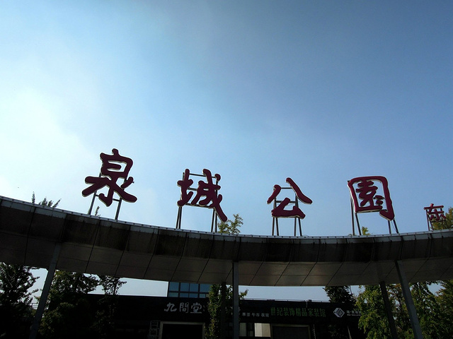 泉城公园东门透过树木,前面湖上游船在行驶着,秋天的季节到处充满着