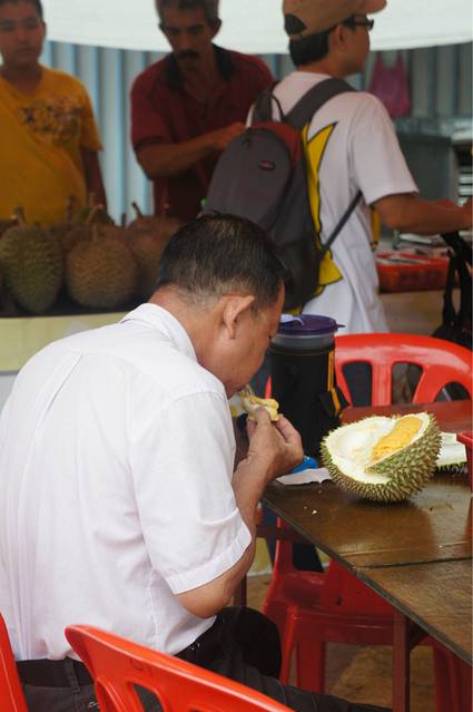这位蜀黍开了个榴莲就独自坐在这里大口大口享受起来了.