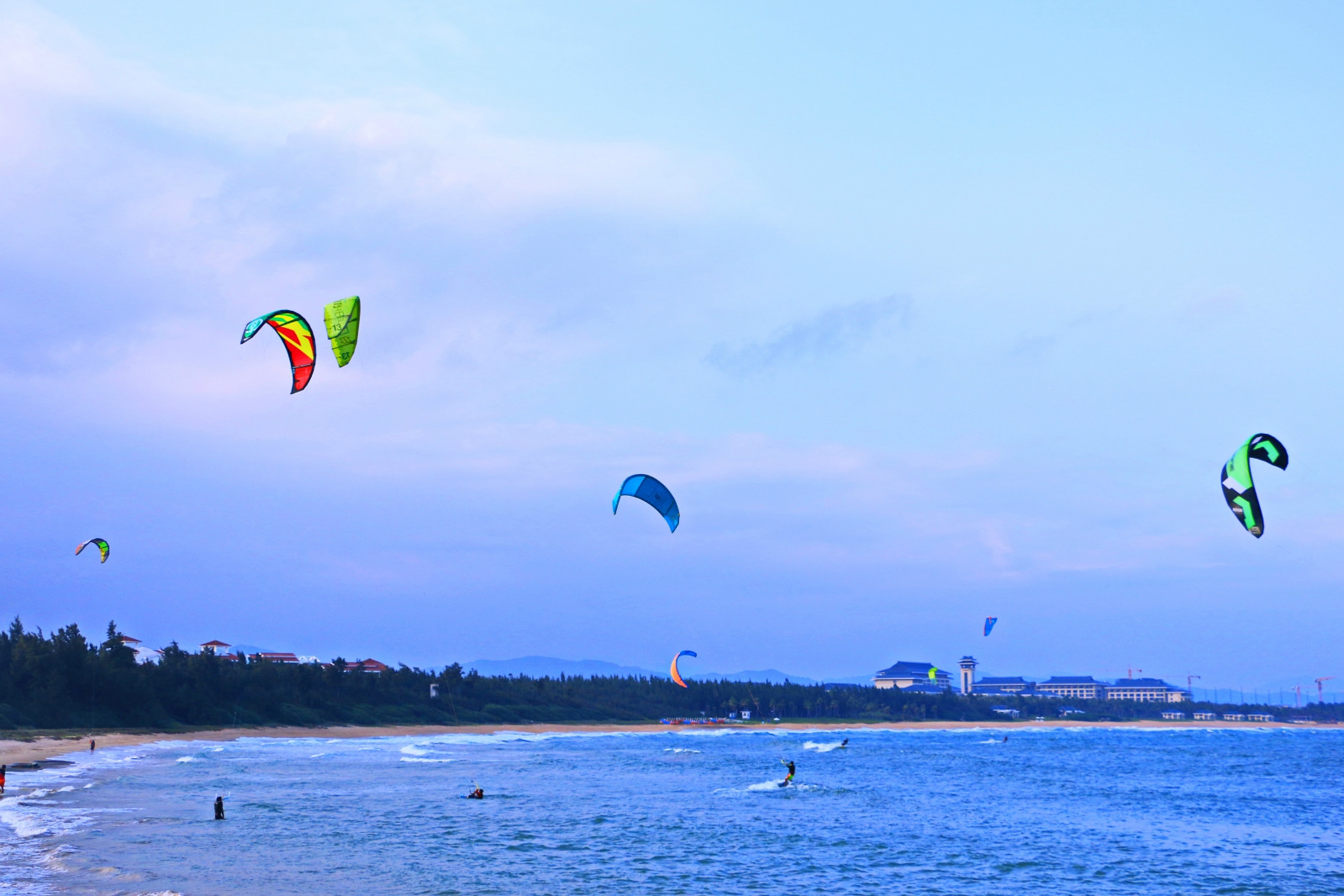 在三亚码头看到许多人在玩海上滑翔伞.