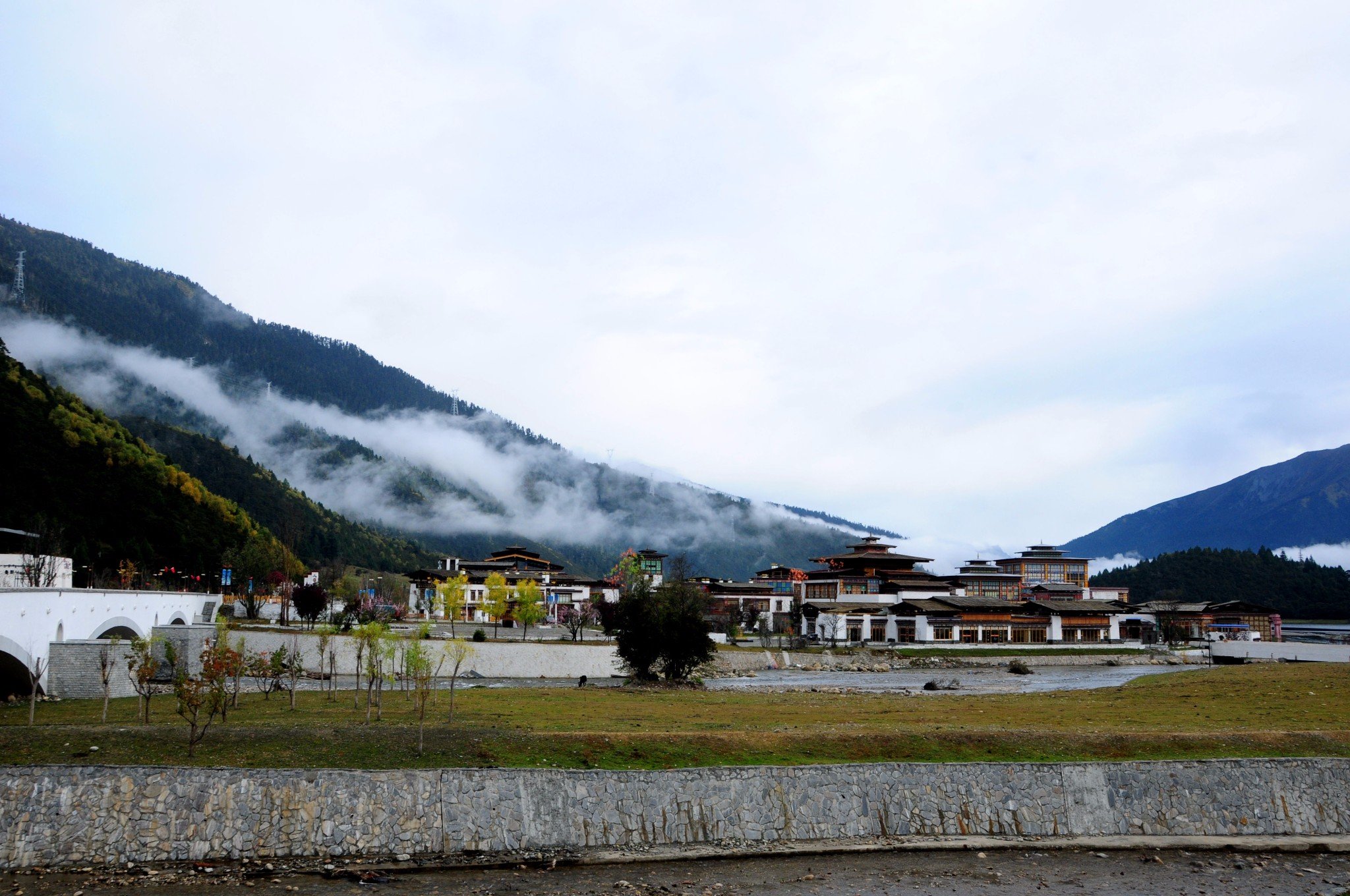 不一会儿,云雾笼罩山峦,星星点点下起了小雨,雨雾中的鲁朗更显圣洁