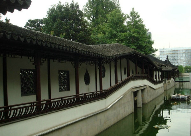 是从环城河的东边遥望那园内古木青竹衬托着青砖白墙华廊倒影蜿蜒曲折