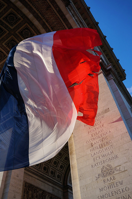 而在无名烈士墓正上方,就飘扬着一面巨型的法国三色国旗.