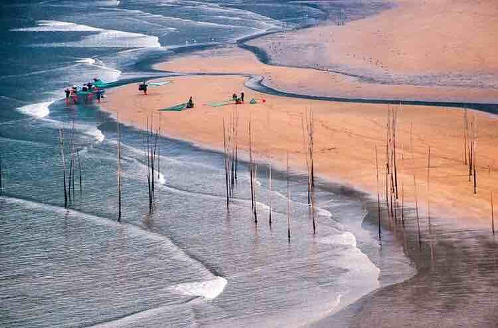 小皓海滩主要以沙质滩涂为主,渔排围绕着一两座海岛呈环形状,远方贴
