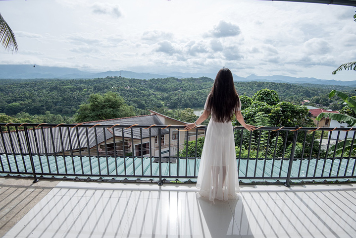 姑娘站在露台的边沿,白色的连衣裙摆通透而轻盈.