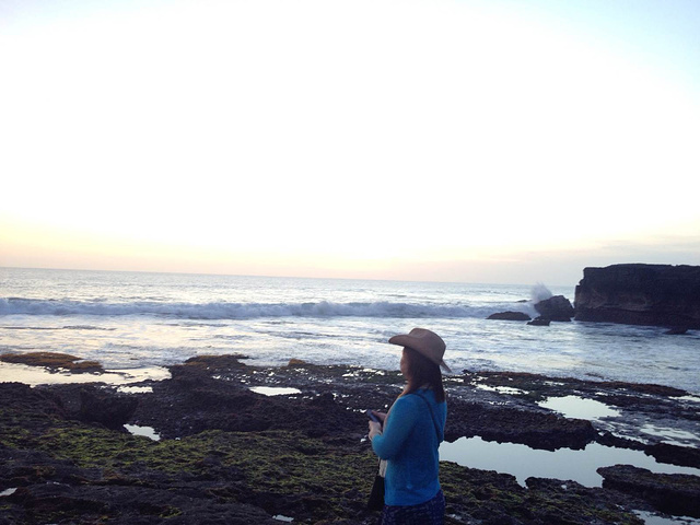 晕黄的日落照射下,海浪凶猛地拍打着海岸,激起千层浪,景色壮观不已