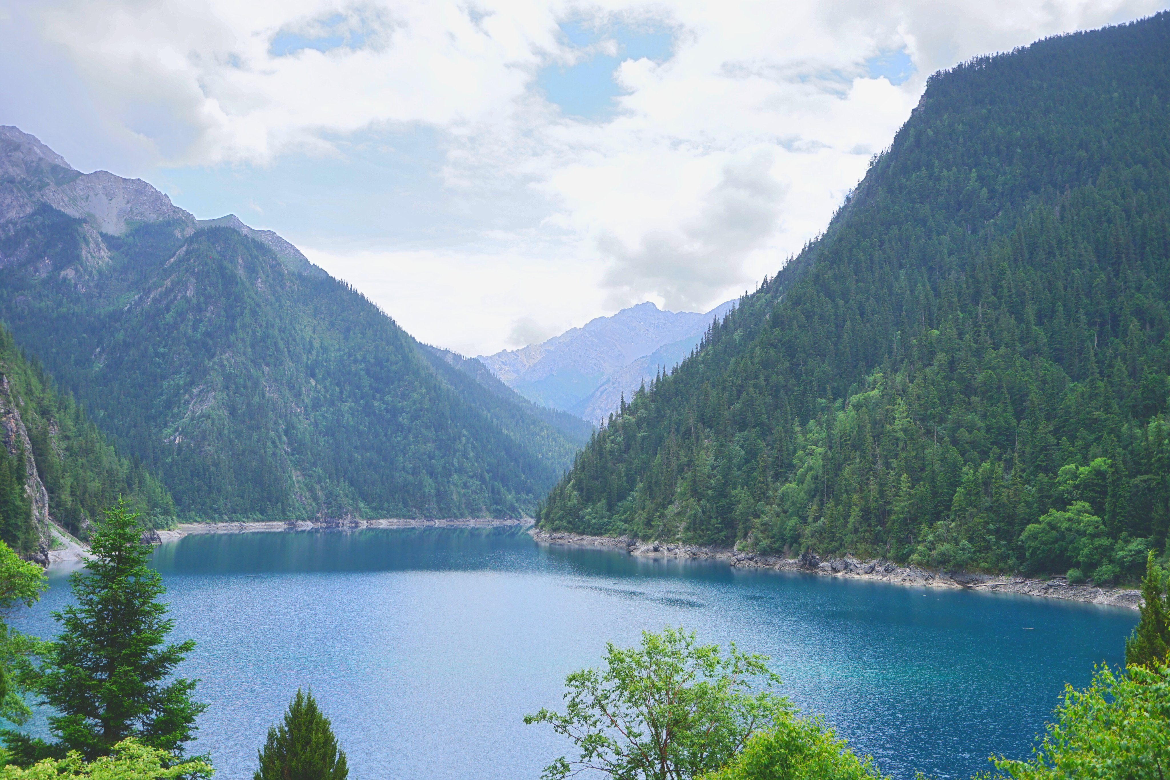 长海呈墨蓝色,四周山峦叠翠,对面的群峰一到初秋便披上了白色的盔甲