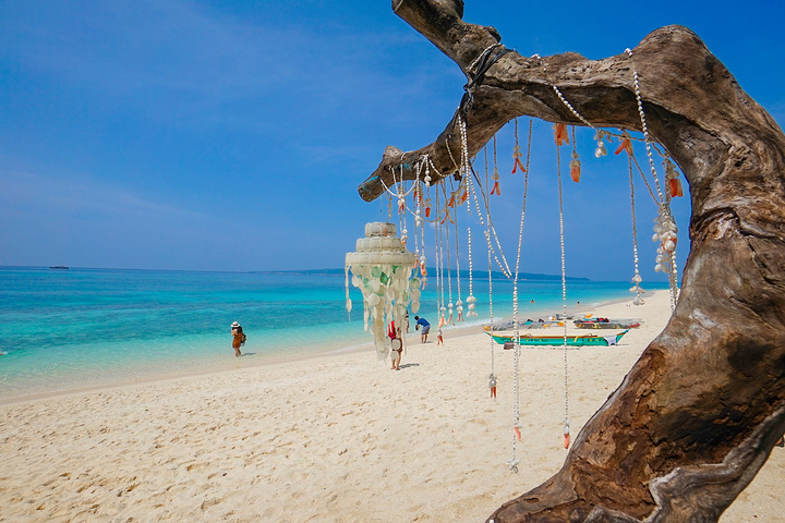 虽然沙滩上全是贝壳碎片略有些硌脚,但海水清澈见底色彩丰裕,游人相对