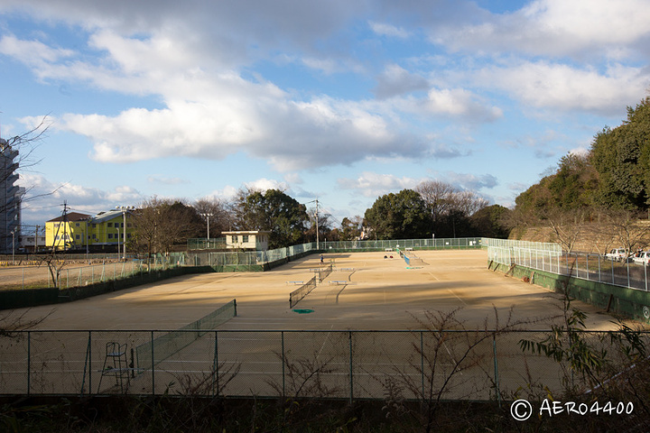 露天网球场,有帅哥在打球.