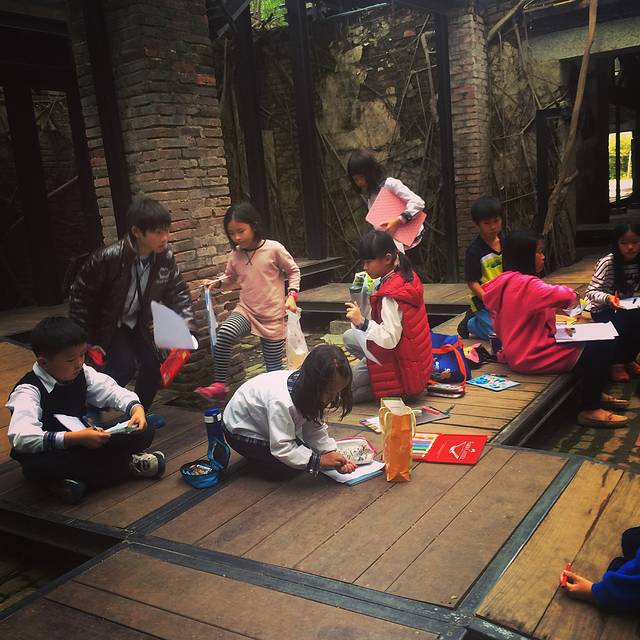 一群小孩趴在树屋的地上画画