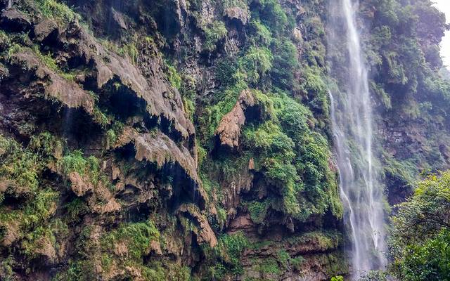 仰望对面的峡谷,一条小水流瞬间行成了大型的瀑布,夹杂着泥沙倾泻而下