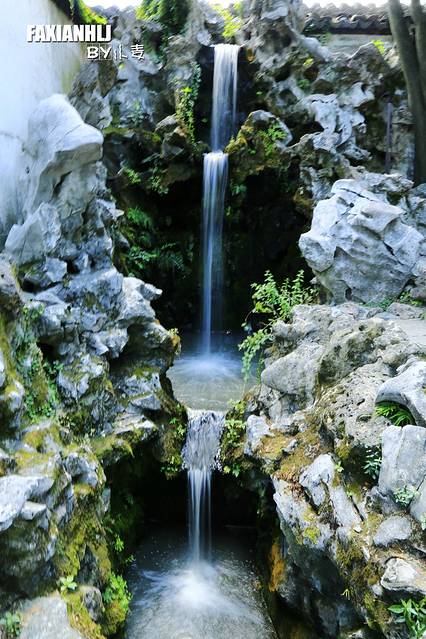 一股清泉经湖石三叠,奔泻而下,形成了苏州古典园林引人注目的人造瀑布