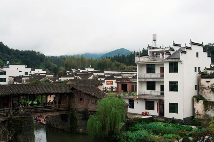 锦峰绣岭,清溪碧河的自然风光之中,房屋群落与自然环境巧妙结合,山水