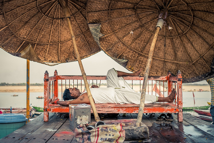 街边有些摆摊卖菜的小贩,不知是谁家的孩子光着屁股睡在摊位上,周围